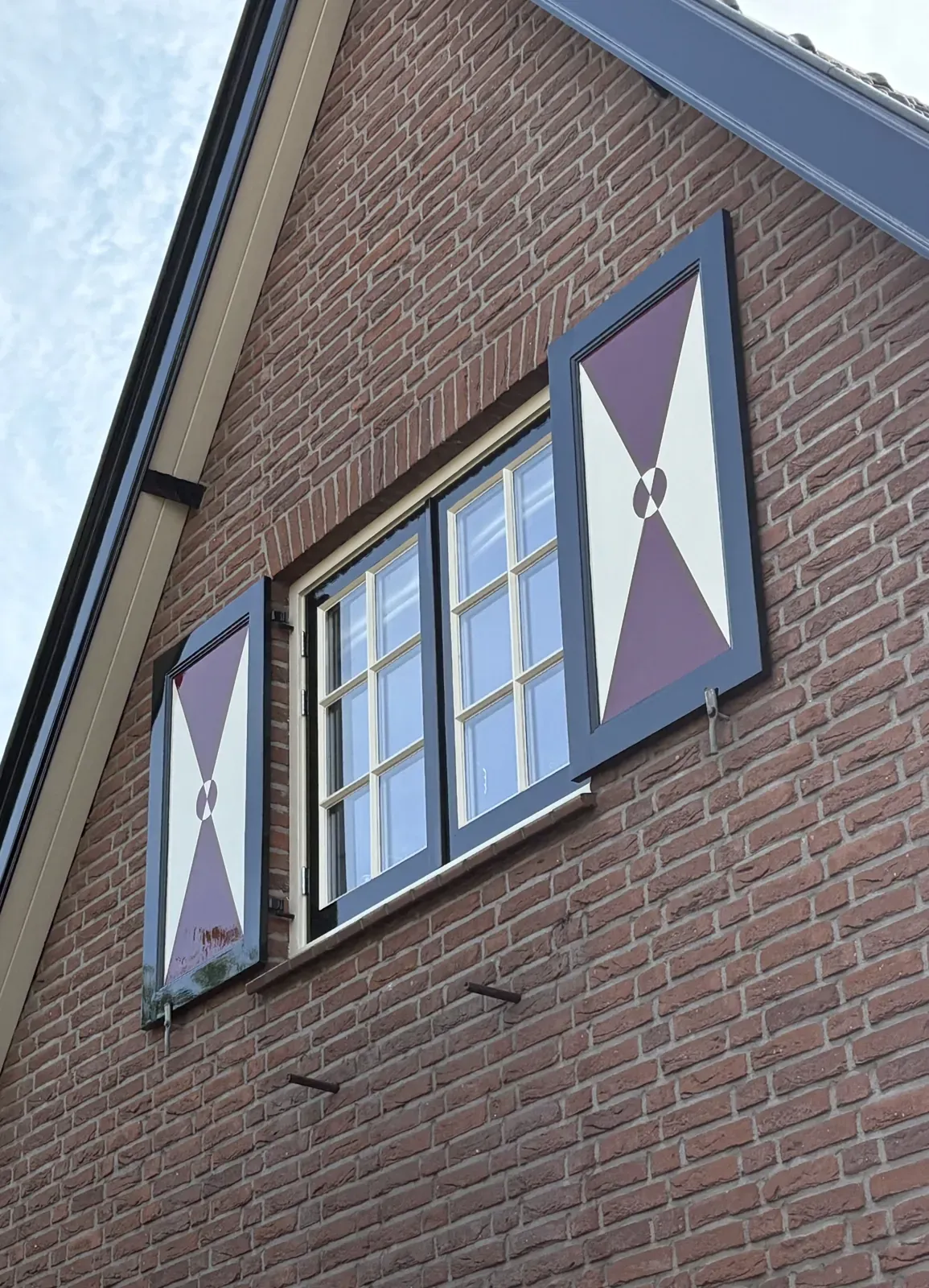 Bakstenen gevel met opnieuw geschilderde luiken